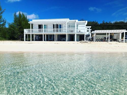 ein weißes Haus am Strand mit dem Wasser in der Unterkunft Caribbean SandCastle home in James Cistern