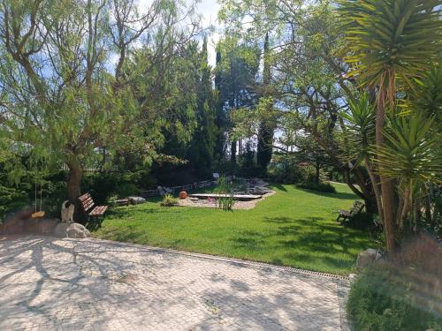 a garden with a bench and a fire pit at Casa Grande in Golpilheira