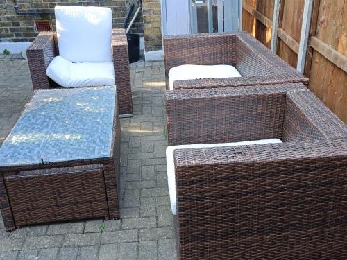 three wicker chairs and a bench on a patio at King-size room in house in London