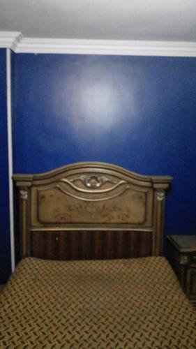 a blue wall with a wooden bed in a room at Giza Great Pyramid in Cairo