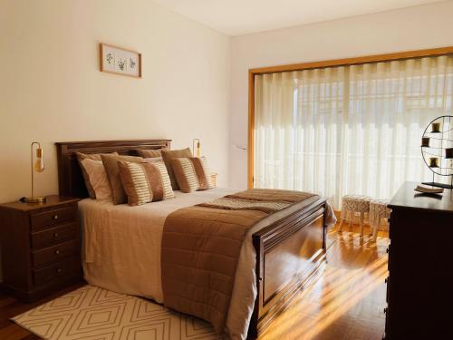 a bedroom with a large bed and a window at Viseu Home in Viseu