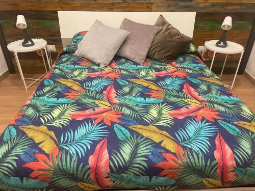 una cama con un edredón colorido con hojas de palmera en Casa Vacirca, en Niscemi
