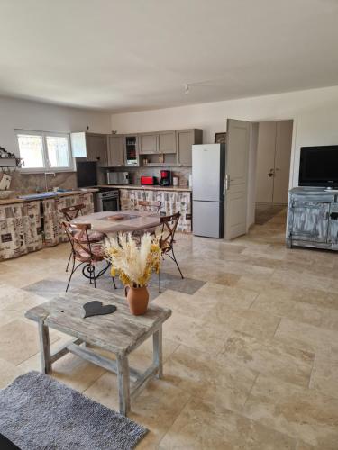 a kitchen with a table and chairs and a refrigerator at Maison de campagne in Soings-en-Sologne