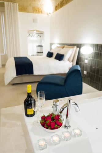 a bathroom with a sink with a bowl of fruit and wine glasses at Casa Minerva - Suite e Relax in Gioia del Colle