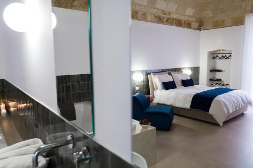a bedroom with a king sized bed and a blue chair at Casa Minerva - Suite e Relax in Gioia del Colle