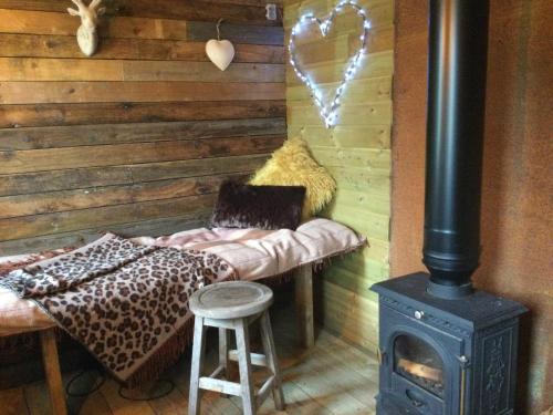a room with a woodburning stove and a bench with a stove at Dolly’s shepherds hut in Trowbridge