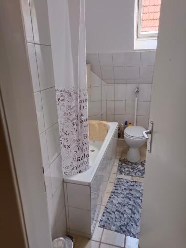 a bathroom with a tub and a toilet at Nette Kuschelige Wohnung in Bochum