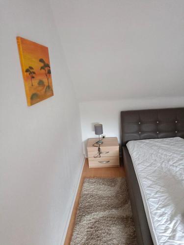 a bedroom with a bed and a painting on the wall at Nette Kuschelige Wohnung in Bochum
