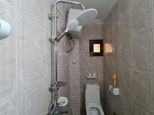 a bathroom with a shower with a toilet and a sink at Appartement meublé grand luxe à Essos in Yaoundé