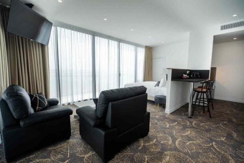 a hotel room with a couch and a chair and a bed at Le Barracuda & Spa, Centre Port, pieds dans l'eau, vue mer in Brest