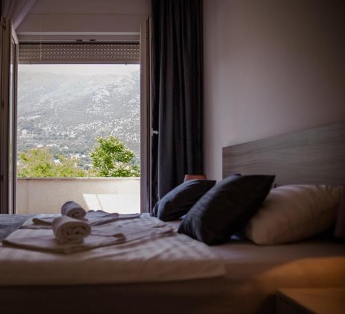 een slaapkamer met een bed en een groot raam bij Villa Mir in Mostar