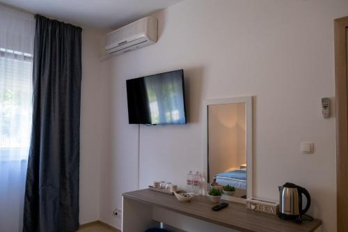 a room with a mirror and a tv on the wall at Villa Mir in Mostar