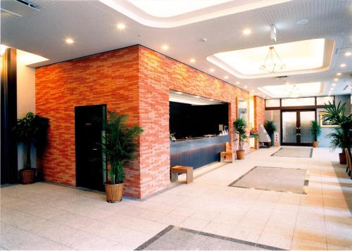 un vestíbulo con una pared de ladrillo rojo y un bar en Route Inn Grantia Hakodate Ekimae, en Hakodate