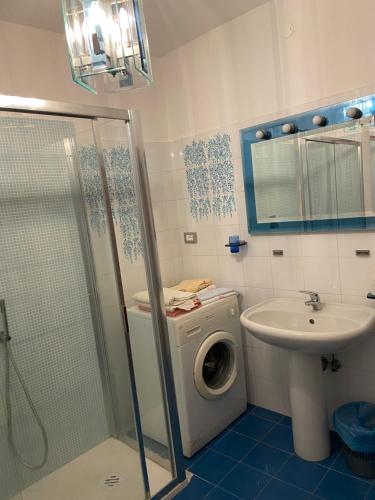 een badkamer met een wasmachine en een wastafel bij Casa Marina in Fosdinovo