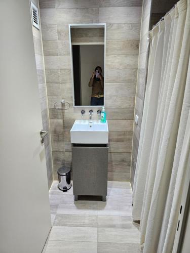 una persona que toma una foto de un baño con lavabo en LaMari en Buenos Aires