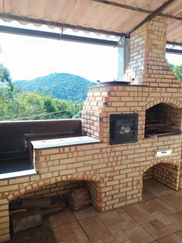 an outdoor brick oven with a view of a mountain at Casa da Montanha in Miguel Pereira