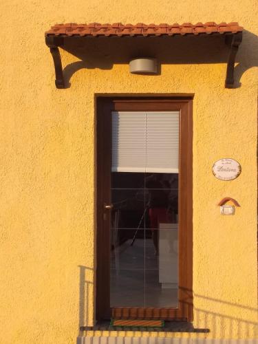 a door to a yellow building with a window at La Cornice dei Monti in Tramonti