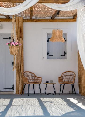 a patio with two chairs and a table and a chandelier at Chora Suite in Alonnisos Old Town