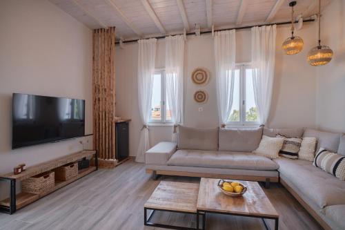a living room with a couch and a flat screen tv at Chora Suite in Alonnisos