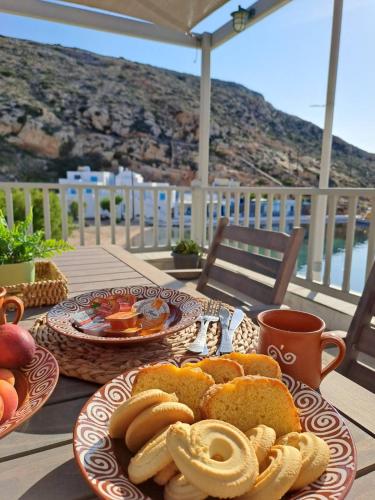 a table with two plates of bread and fruit on it at Poudas House in Cherronisos
