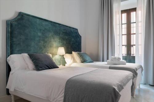 a bedroom with two beds and a large headboard at San Buenaventura Apartment 13 in Seville