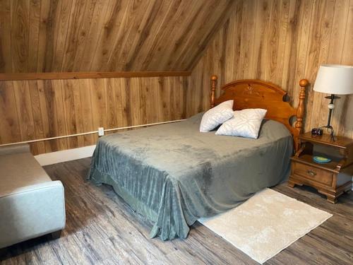 een slaapkamer met een bed in een kamer met houten wanden bij Fabulous Barre Apts! in Barre