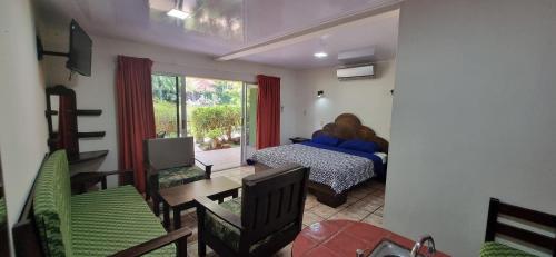 1 dormitorio con 1 cama, mesa y sillas en Mangaby Playa Hermosa, en Playa Hermosa