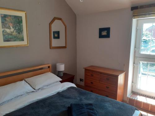 a bedroom with a bed and a dresser and a mirror at Characterful Cottage near the Sea, Beach, Pier & Shops in Weston-super-Mare