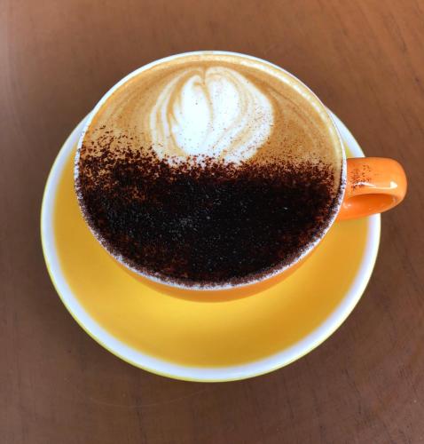 a cup of coffee on a yellow plate on a table at Olympia by the lake in Lausanne