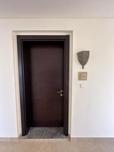 a black door in a room with a vase on the wall at Dead Sea view Elite apartment Samara Resort traveler award 2024 in Sowayma