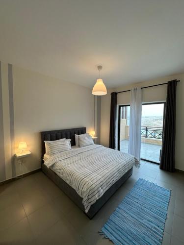 a bedroom with a bed with a view of the ocean at Dead Sea view Elite apartment Samara Resort traveler award 2024 in Sowayma