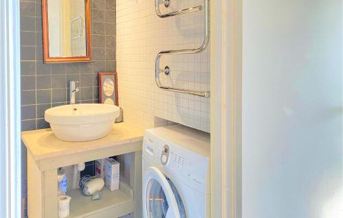 uma casa de banho com um lavatório e uma máquina de lavar roupa em 3 Bedroom Nice Home In Burgsvik em Burgsvik