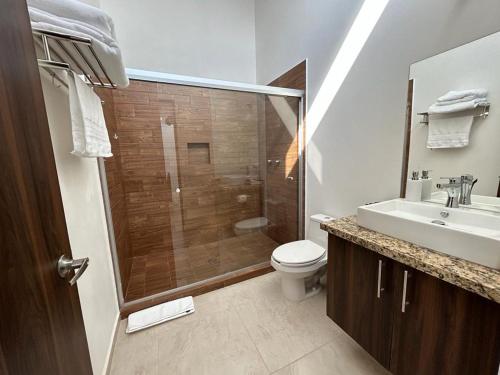 een badkamer met een douche, een toilet en een wastafel bij Casa Cuxtal Tus mejores momentos in Juriquilla