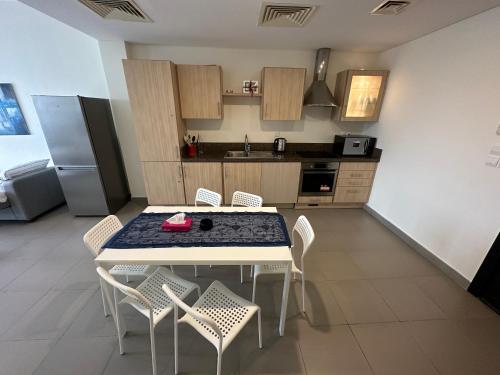 a kitchen with a table and chairs in a room at Dead Sea view Elite apartment Samara Resort traveler award 2024 in Sowayma