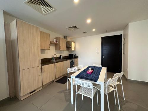 a kitchen with a table and chairs in a room at Dead Sea view Elite apartment Samara Resort traveler award 2024 in Sowayma