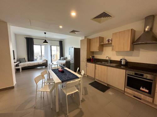 a kitchen and living room with a table and chairs at Dead Sea view Elite apartment Samara Resort traveler award 2024 in Sowayma