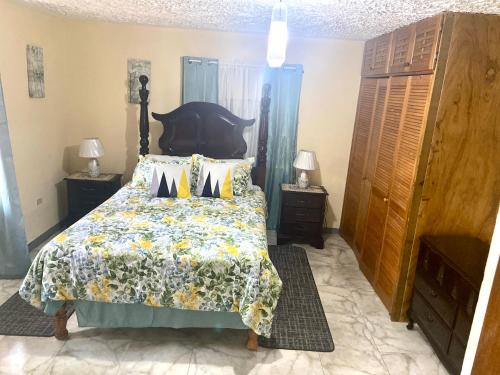 a bedroom with a bed with a floral bedspread at Murray's Cool Spot in Mandeville