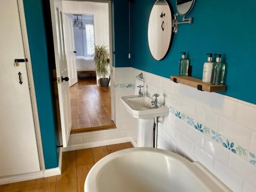 La salle de bains est pourvue de toilettes, d'un lavabo et d'un miroir. dans l'établissement Camelford Street Cottage - Brighton, à Brighton et Hove