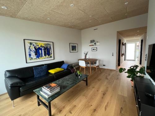 a living room with a black couch and a table at Atlantic Jewel in Tórshavn