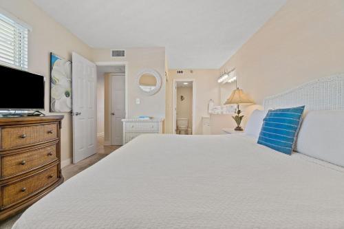 a bedroom with a large white bed and a flat screen tv at Perdido Sun 610 in Perdido Key