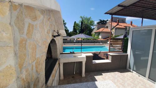 a stone wall next to a swimming pool at Apartments Meštrović in Kaštela