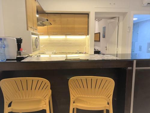 two chairs sitting at a kitchen counter with a counter top at Chalet at Aqualand Resort in Batroûn