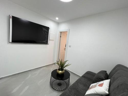 a living room with a couch and a tv on a wall at בוטיק צ'יל אאוט - Boutique Chill Out in Eilat