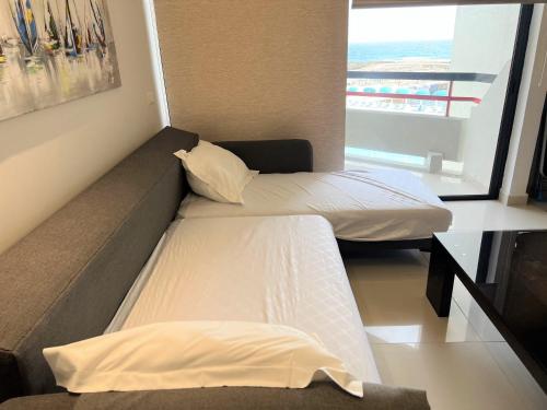 a small room with two beds and a window at Beachfront Chalet in Aqualand Resort - Batroun in Batroûn