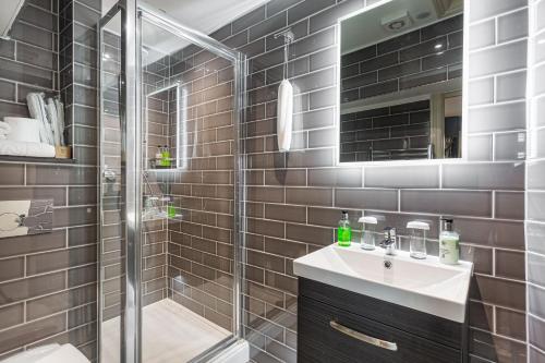 a bathroom with a glass shower and a sink at The George Hotel, Amesbury, Wiltshire - The Coaching Inn Group in Amesbury
