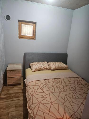 een kleine slaapkamer met een bed en een raam bij Wild Beauty house Skadar lake in Cetinje