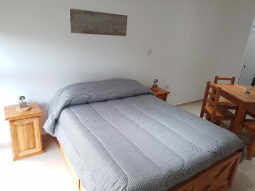a small bed in a room with a table at Departamento Centrico Ana in Ushuaia