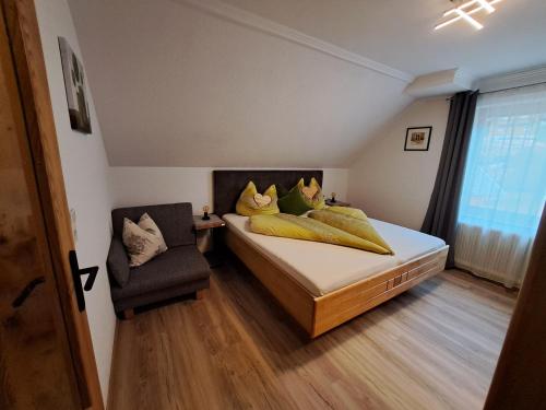 a bedroom with a bed with yellow pillows and a chair at Biobauernhof Tonimörtl in Mariapfarr