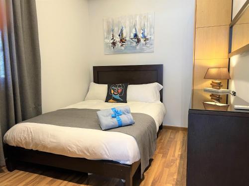 a bedroom with a bed with two blue pillows on it at Chalet at Aqualand Resort in Batroûn