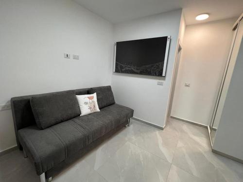 a living room with a couch and a flat screen tv at בוטיק צ'יל אאוט - Boutique Chill Out in Eilat